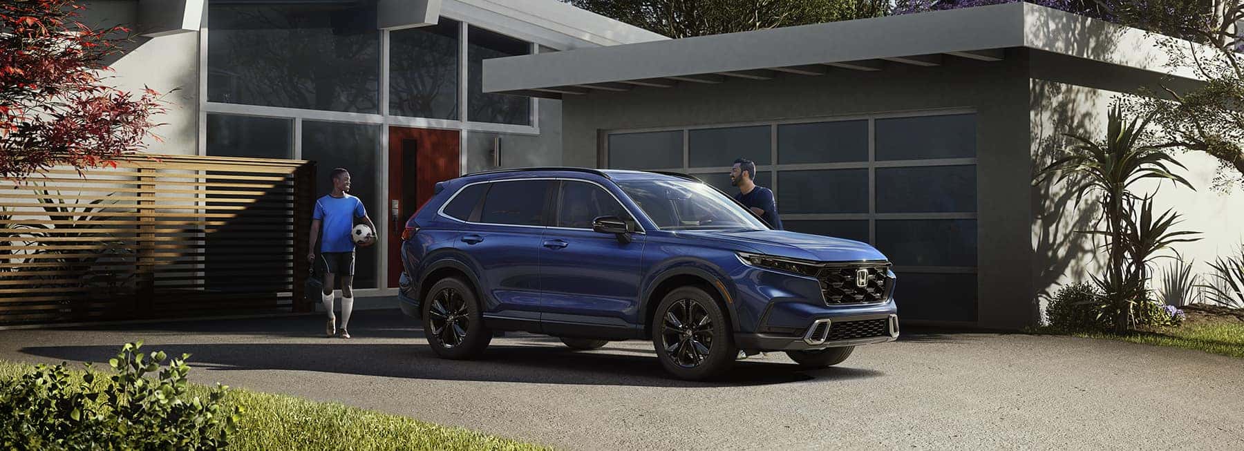 Two men walking towards a blue Honda CR-V