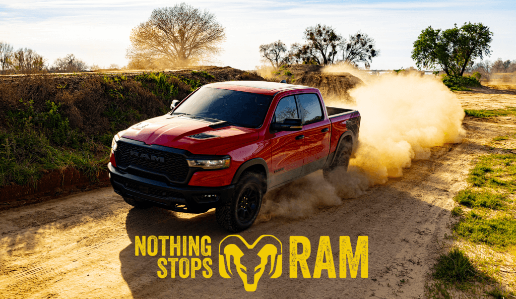 Nothing stops Ram red Ram truck on a dirt road kicking up dirt