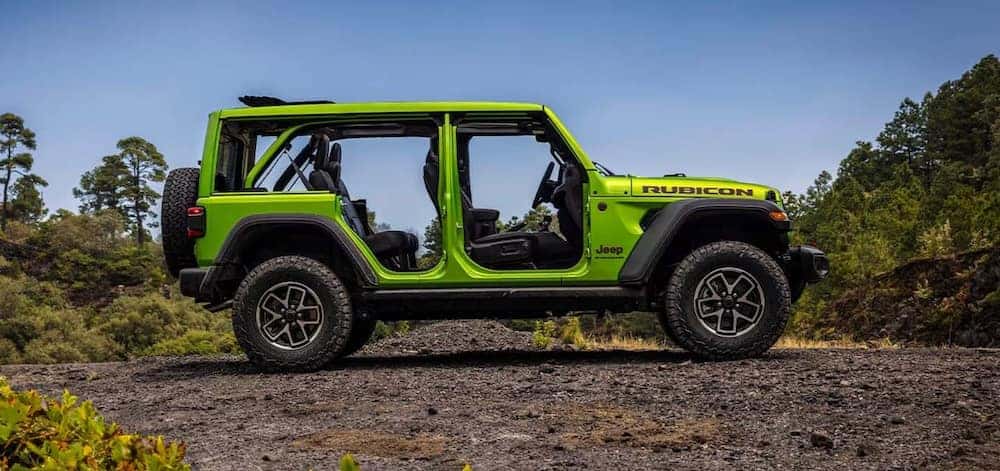 A bright green 2026 Jeep Wrangler SUV parked on a dirt road