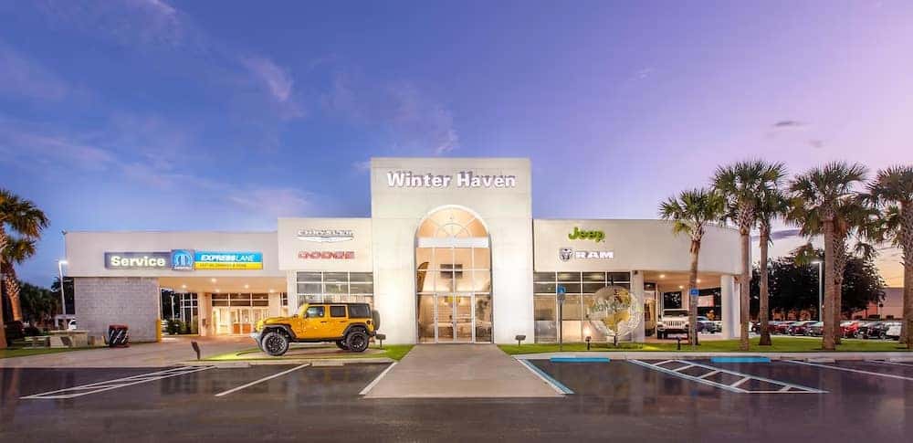 The main entrance of Dodge Chrysler Jeep Ram FIAT of Winter Haven with a yellow Jeep parked in front