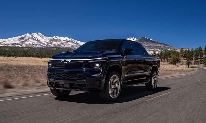New Chevrolet Silverado EV Driving On Highway Near Mountain Range
