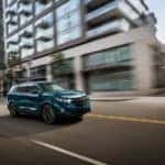 A blue 2021 Chevrolet Equinox LT driving on an empty street - El Dorado Chevrolet in McKinney, Texas