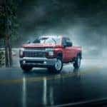 A red 2021 Chevrolet Silverado 2500HD on a wet road - El Dorado Chevrolet in McKinney, Texas