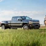 A woman riding a horse next to a black 2019 Chevrolet Silverado 3500 HD | El Dorado Chevrolet in McKinney, Texas