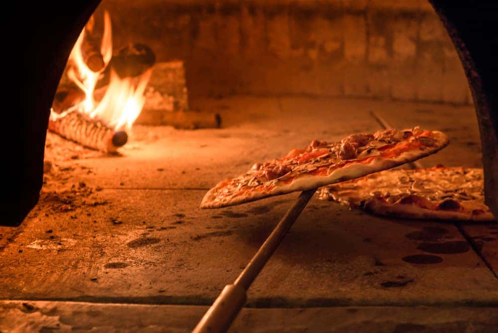 Brick oven with flames and ember ready to cook a delicious pizza