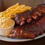 Pork ribs back with french fries and coleslaw salad on the side. Shallow depth of field.