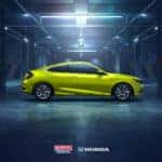 A lime green sedan in a lighted showroom