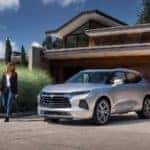 A man and woman next to a silver 2019 Chevrolet Blazer - Graff Chevrolet in Grand Prairie, Texas
