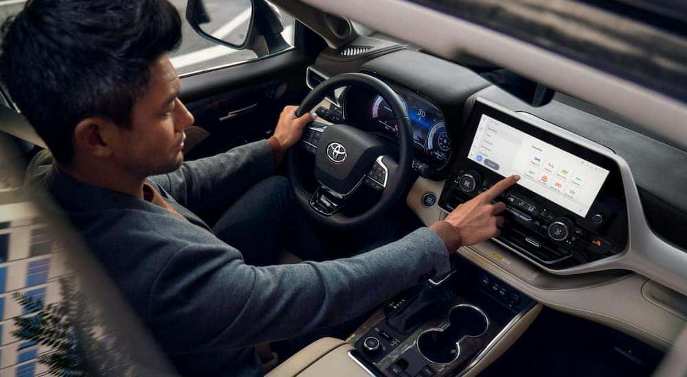 Overhead view of a driver using the infotainment screen in a 2024 Toyota Highlander Platinum at a Toyota dealer near Mechanicsville.