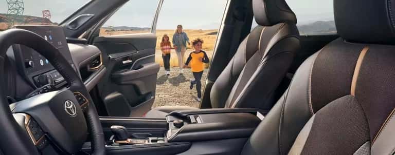 A family is shown approaching a 2024 Toyota Grand Highlander.