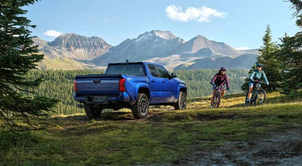 A blue 2025 Toyota Tacoma TRD Sport is shown from the rear at an angle.