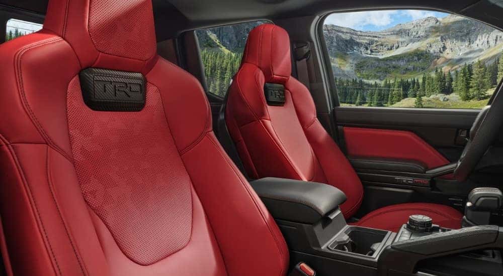 The red interior of a 2025 Toyota Tacoma TRD Pro is shown from the passenger side.
