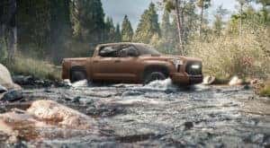A brown 2025 Toyota Tundra TRD Pro is shown driving through a creek.