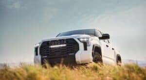 A white 2024 Toyota Tundra SR5 CrewMax is shown parked on a hill.