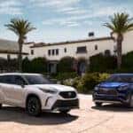 Two 2026 Toyota Highlander's for sale parked in front of a home.