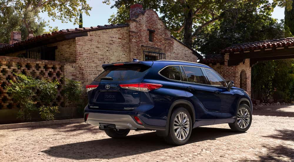 Blue 2026 Toyota Highlander from the rear at an angle parked in driveway.