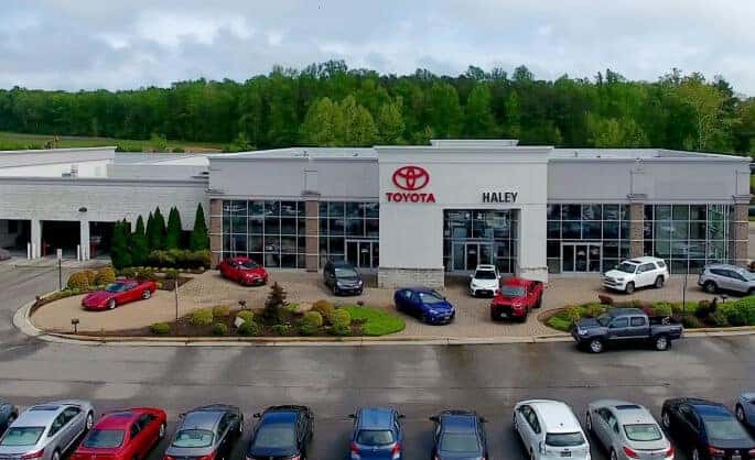 Aerial view of Haley Toyota of Richmond with a lineup of new and used Toyota vehicles parked out front.