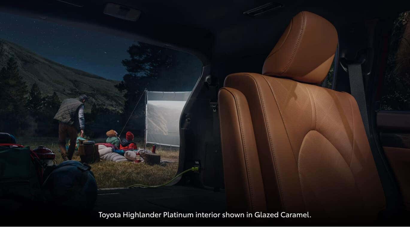 Interior rear cargo view looking out from a Toyota Highlander Platinum at a campsite.