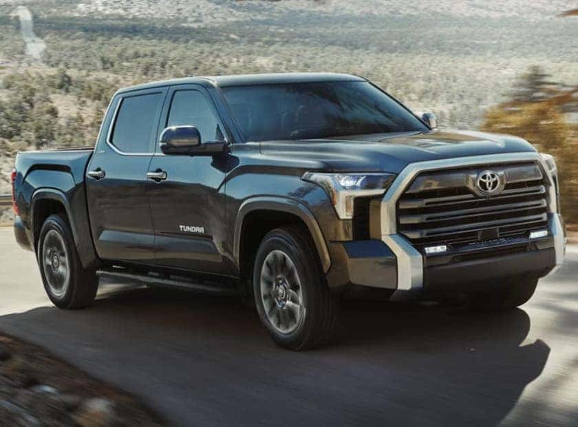 Toyota Tundra pickup truck driving on a road through a mountainous landscape.