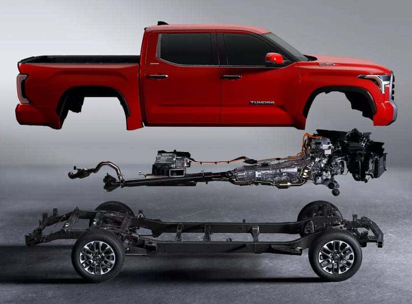Exploded view of a red Toyota Tundra showing the truck body, hybrid powertrain, and chassis components.