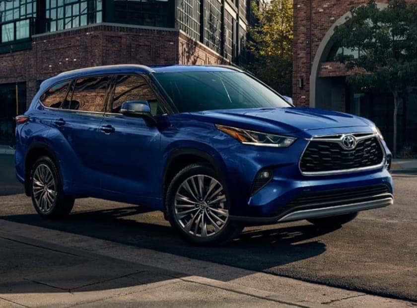 Blue Toyota Highlander SUV shown from a front three-quarter view on a city street.