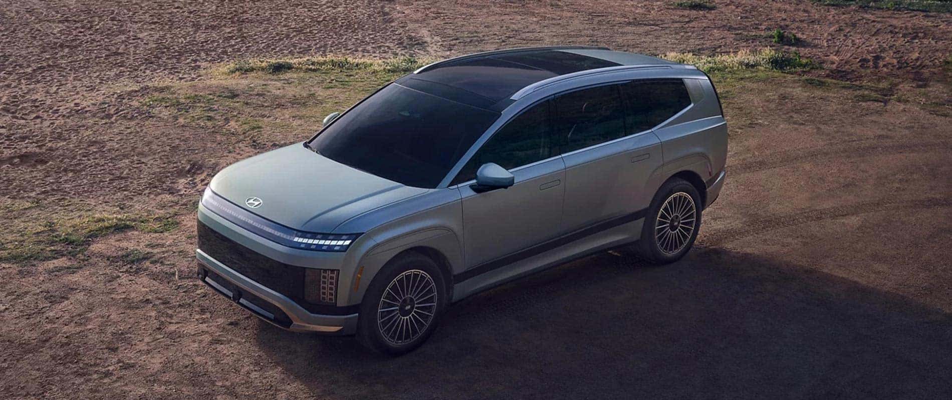 A gray 2026 Hyundai IONIQ 9 parked in a dirt field.