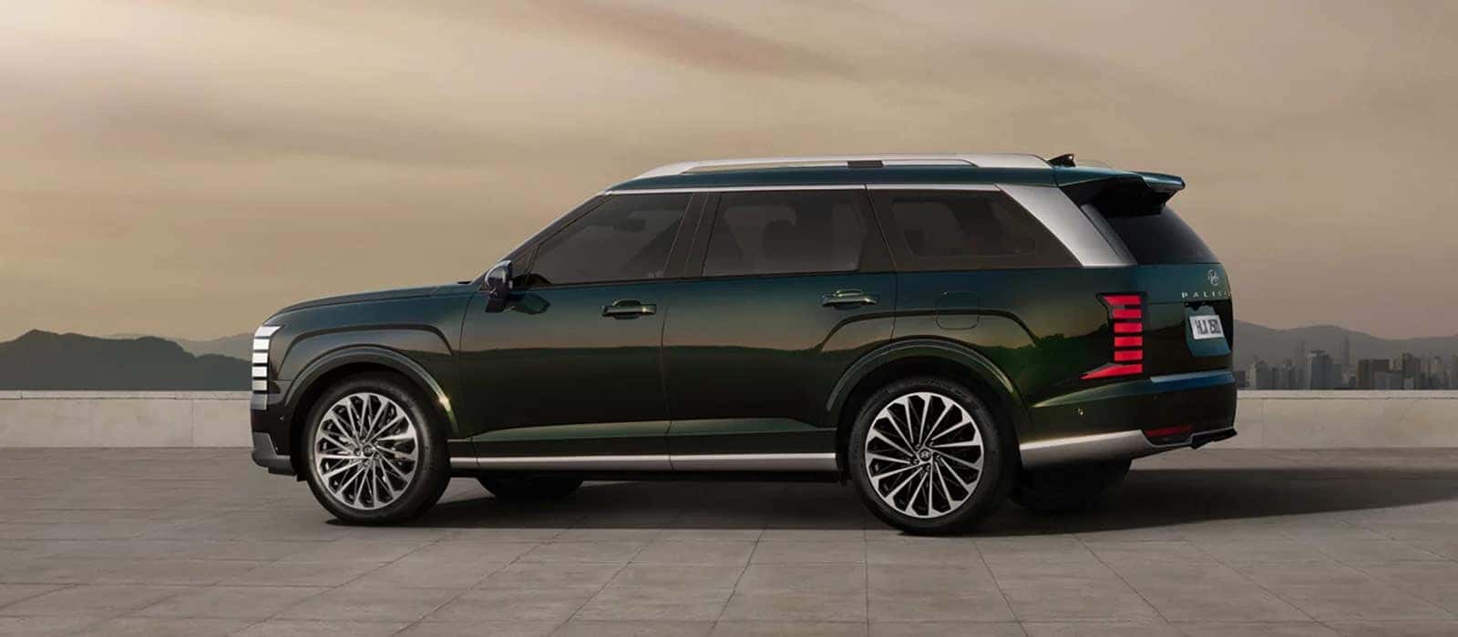 A green 2026 Hyundai Palisade in profile against a city backdrop.