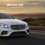 white mercedes-benz amg sedan speeding down highway