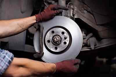 Car mechanic repairing brakes