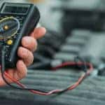 Auto mechanic using digital multimeter