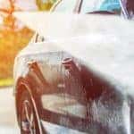 washing black car with hose