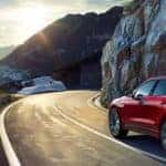 red 2019 jaguar f-pace driving on a mountain highway rounding a corner