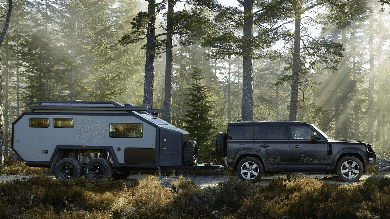 2026 Defender 110 utilizing its high towing capacity to haul heavy equipment