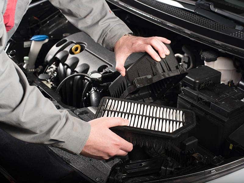 Mechanic changing the air filter on a car