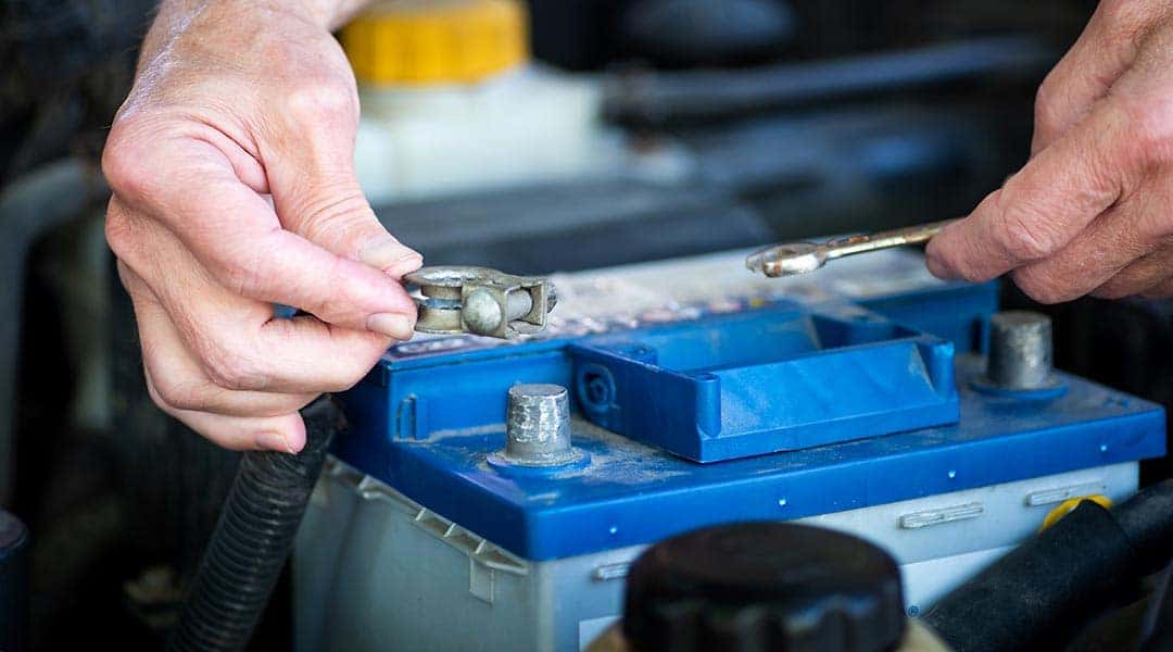 Battery terminals being removed from car battery.