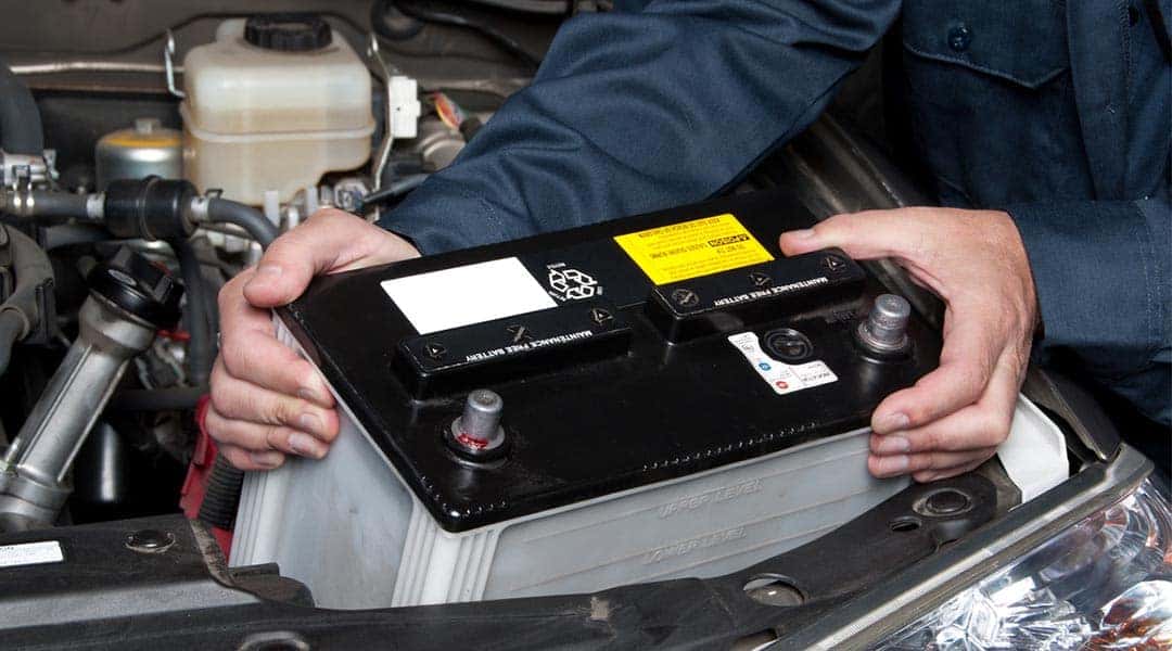 Battery being removed from engine bay.