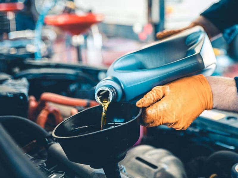 Pouring Motor Oil in to funnel.