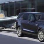 2019 land rover discovery in blue towing a small boat