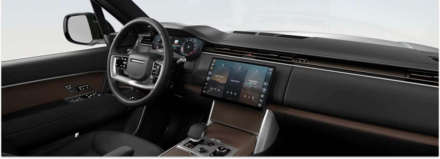 Front interior view of a 2026 Range Rover showing the dark dashboard, center touchscreen, and leather steering wheel.