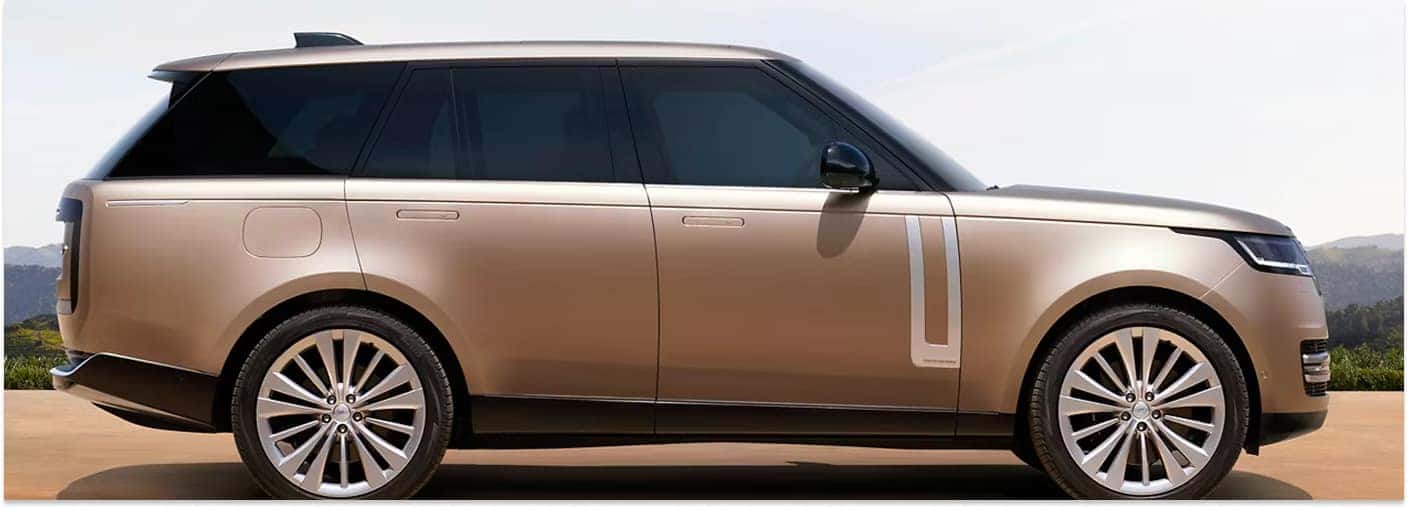 Side profile view of a gold metallic Range Rover SUV with silver multi-spoke alloy wheels.