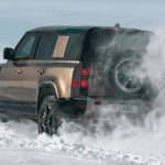 Defender driving away in snow