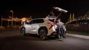 White Toyota RAV4 Prime XSE with two people sitting and talking in trunk