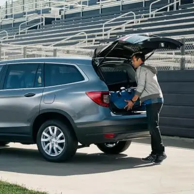 Person loading items into back of a trunk