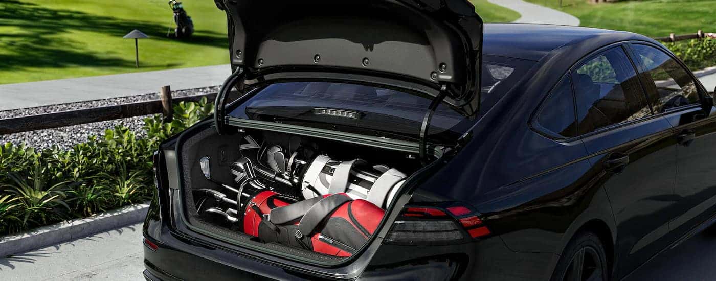 A close-up on the open trunk of a black 2025 Honda Accord SE.