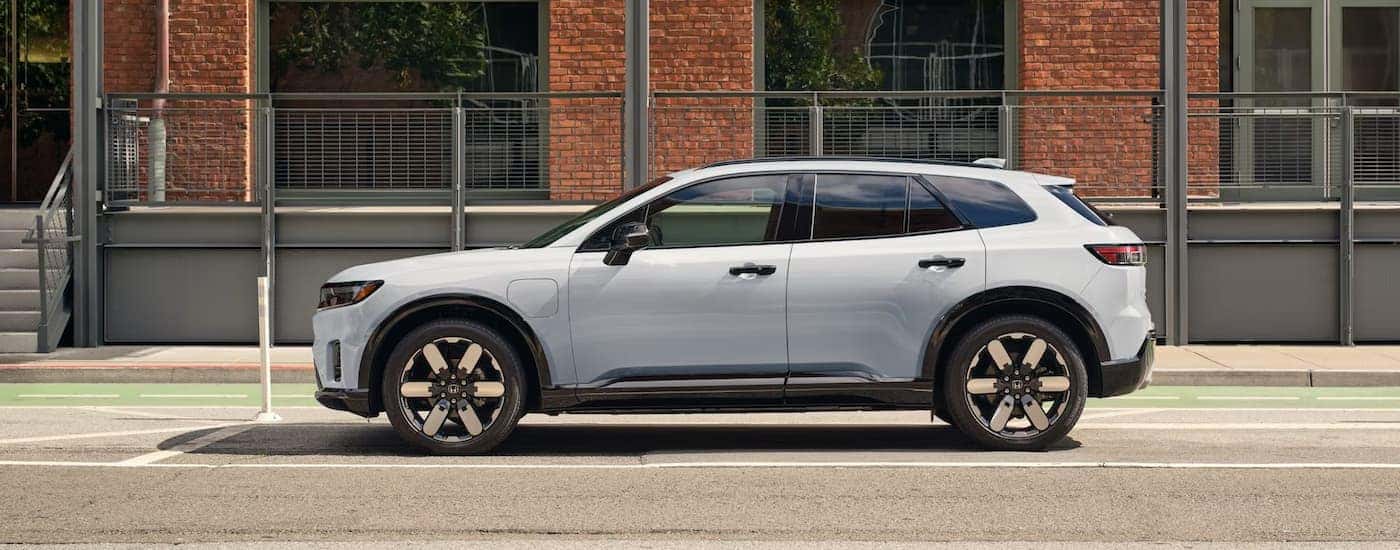 A white 2025 Honda Prologue Elite parked on the side of a street.