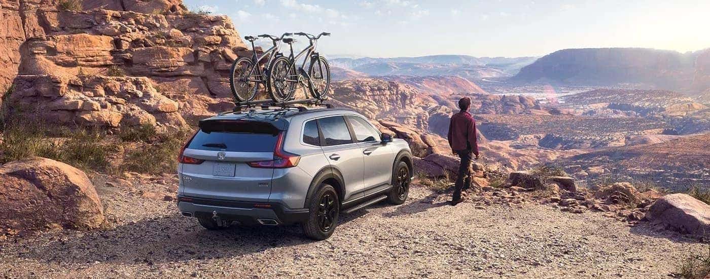 Rear view of a grey 2023 Honda CR-V Sport Touring Hybrid parked on a cliff.