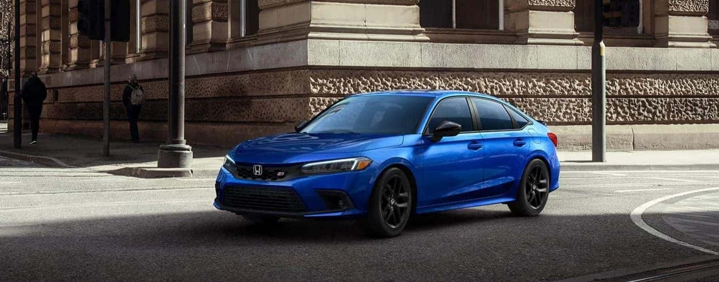 A blue 2023 Honda Civic Si is shown driving to a Honda dealer near Coventry.