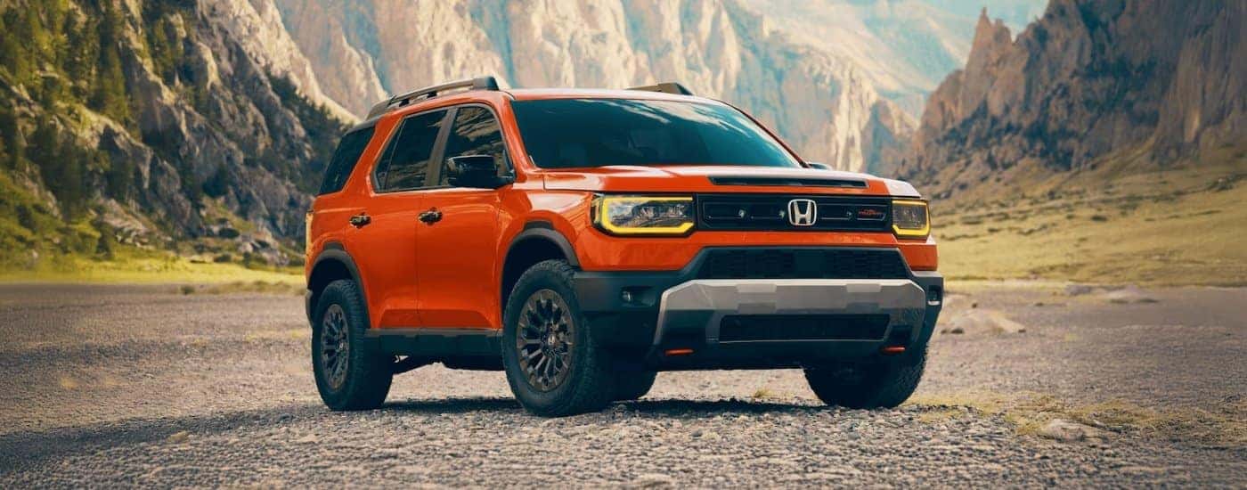 An orange 2026 Honda Passport Trailsport is shown from the front at an angle.