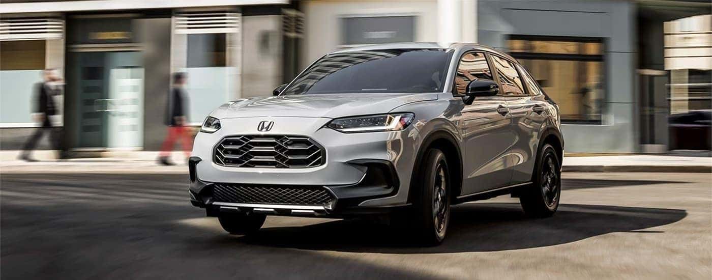 A used gray 2023 Honda HR-V Sport driving in a city