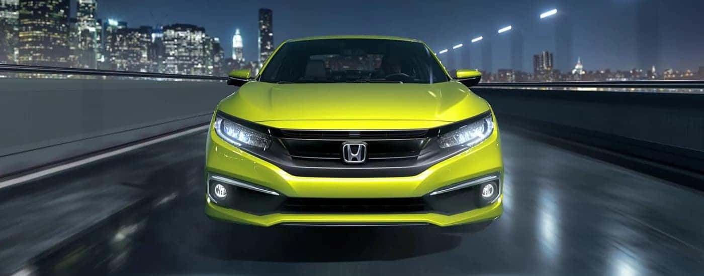 Yellow used 2019 Honda Civic Touring for sale near Windsor driving down a road.